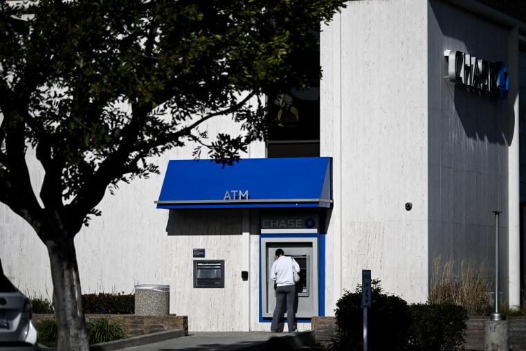 A customer uses an ATM outside of a Chase Bank branch in Rolling Hills Estates, Calif. on March 13, 2023. 